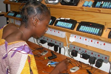A villager in Garoua-Boulai, Cameroon charges phones at a solar power station